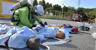 Firefighters in protective gear taking part in a training exercise in a city environment.