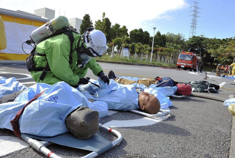 Firefighters in protective gear taking part in a training exercise in a city environment.