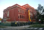 A red-brick public school building photographed from the street