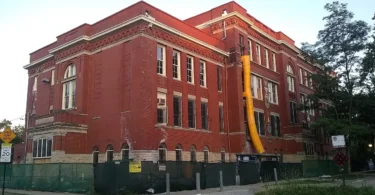 A red-brick public school building photographed from the street