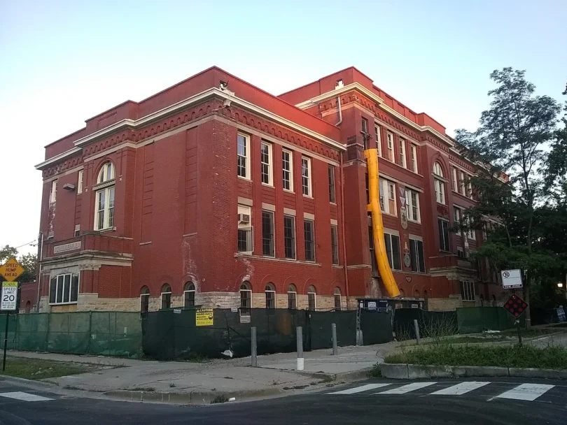 A red-brick public school building photographed from the street
