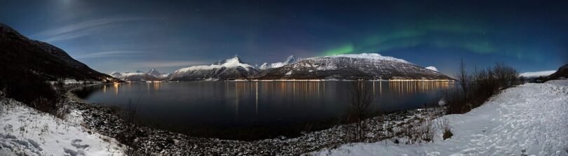 Bright aurora lights dancing across a dark night sky during a solar storm.