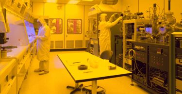 Semiconductor cleanroom engineers working on silicon wafer production lines